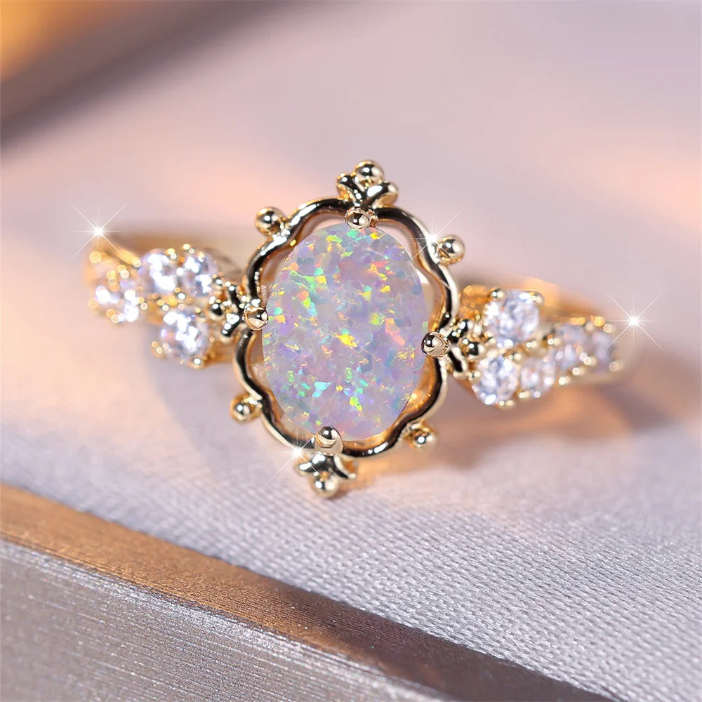 “White Fire Opal Oval Blossom Ring – Gold Filled Elegance”
A luminous White Fire Opal, glowing with shifting rainbows, rests at the heart of a delicate golden Blossom. Its oval cut catches the light with every movement,